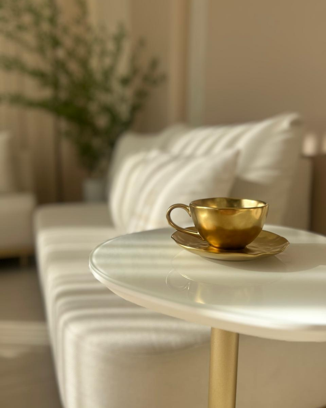 Detalhe da sala de espera, com xícara dourada sobre mesa lateral